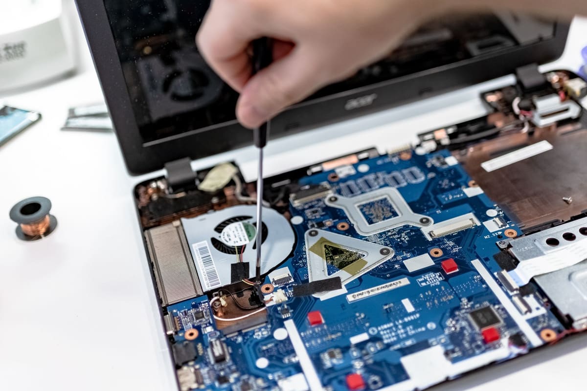 Técnico reparando uma placa na bancada da assistência